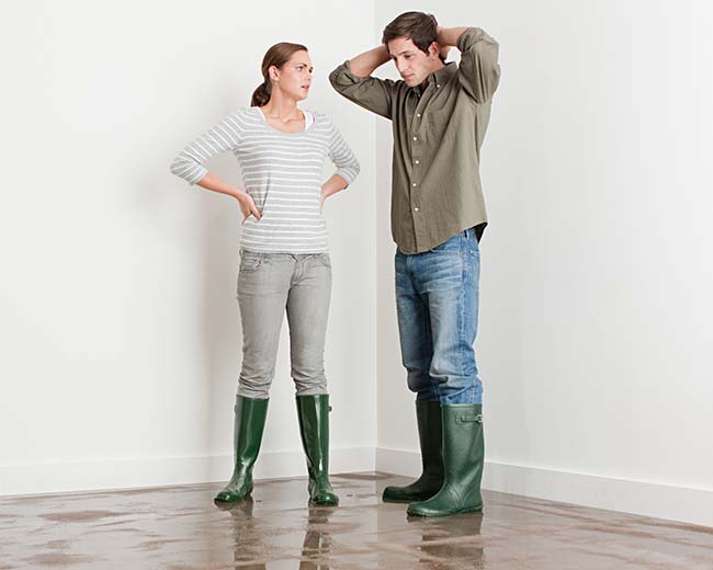 Couple standing together looking concerned about property damage
